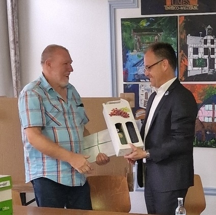 Bild: VG-Bürgermeister Güllering bedankt sich bei dem ehemaligen Ortsbürgermeister mit einem Abschiedsgeschenk