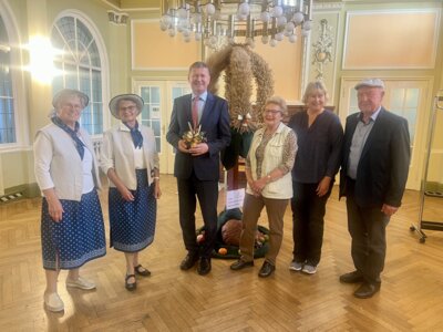 Foto: Die zweitplatzierte Erntekrone aus dem diesj&auml;hrigen Erntekronenwettbewerb ist bis Mitte Dezember im Landratsamt in Senftenberg ausgestellt. Landrat Siegurd Heinze (3.v.l.), und B&auml;rbel Hertam (2.v.r.), Leiterin vom Sachgebiet Landwirtschaft haben die Krone vom Lindenauer Flechtteam in Empfang genommen. (Bild: Landkreis OSL/Theresa Pusch)  (Bild vergr&ouml;&szlig;ern)