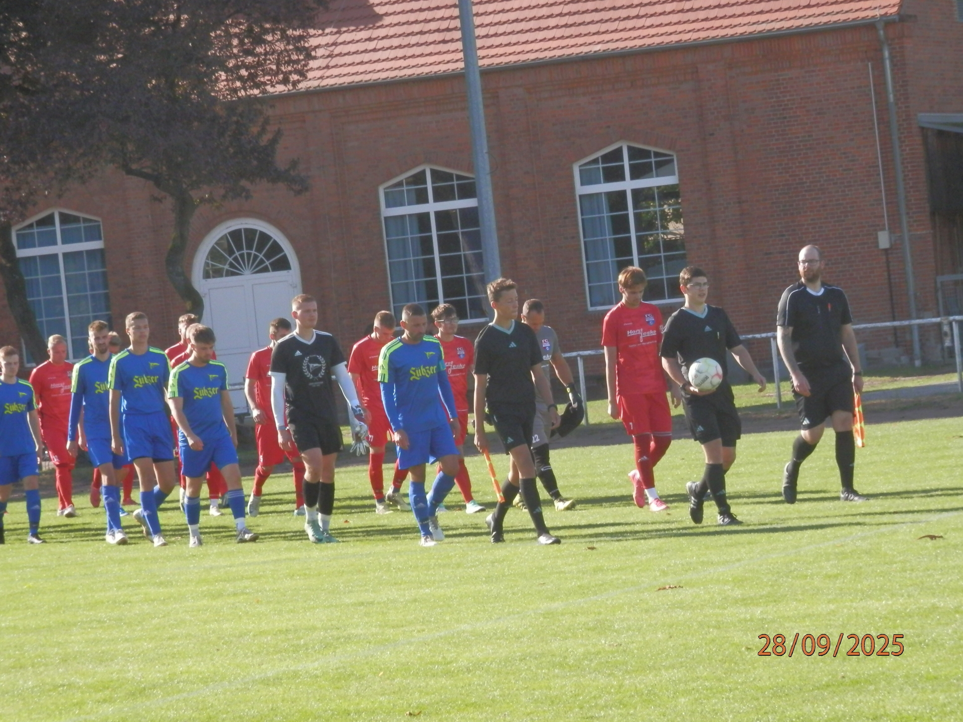 Bild: Schiri Jan Porstner (Eldena) mit den Teams um die Mannschaftskapitäne Florian Schwarz Lübz (links in blau) und Max Levetzow Warin (rechts) beim Auflaufen.
