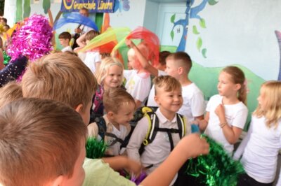 durch ein Spalier von Kindern und ein Meer von Puscheln und T&uuml;chern in die Klasse. Dort erlebten wir unsere erste Schulstunde.  (Bild vergr&ouml;&szlig;ern)