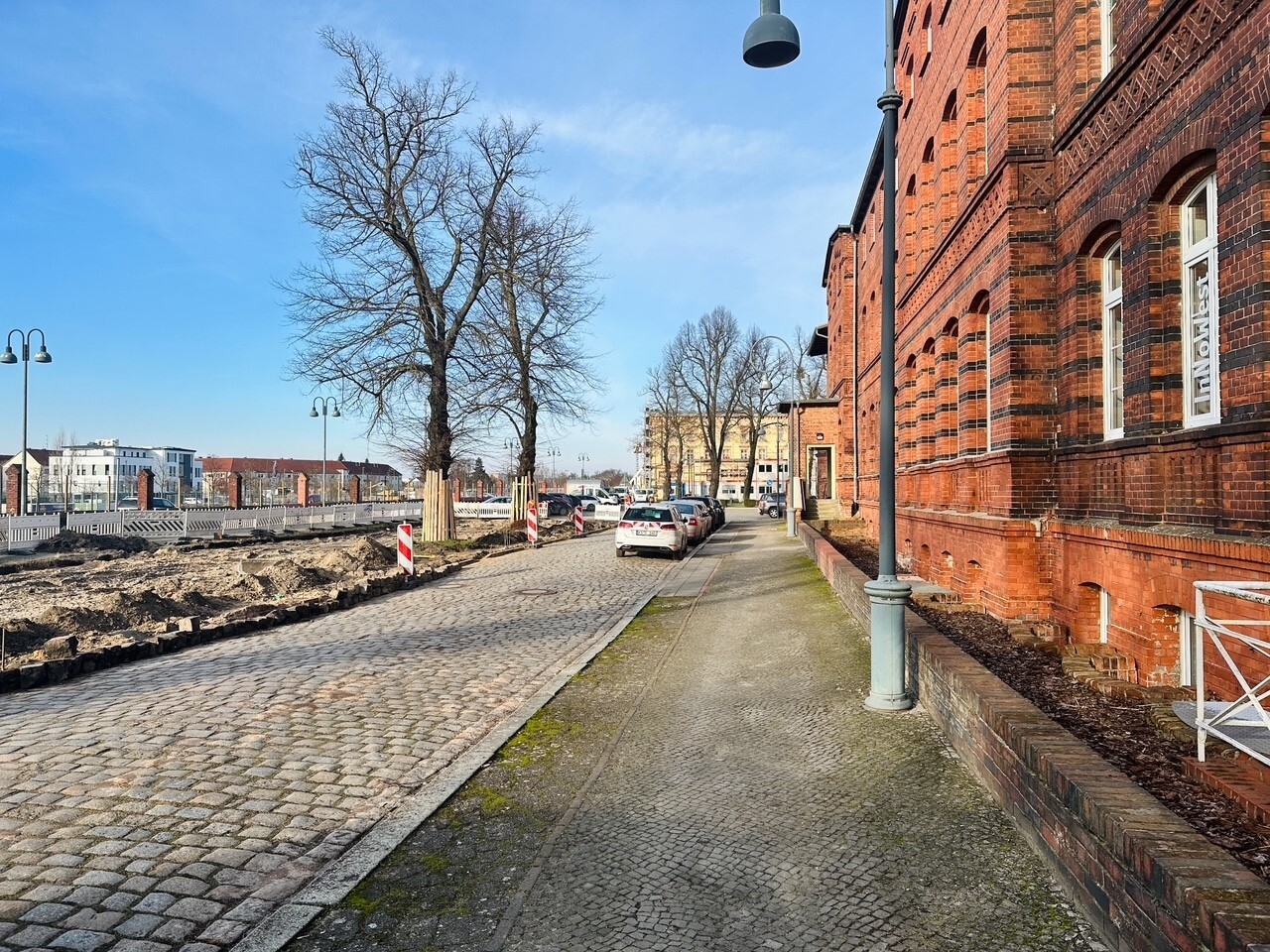 Bild: Der Gehweg an der ehemaligen Zufahrt zum Bahnhofsempfangsgebäude wird mit bestehenden Materialien aufgearbeitet und die Beleuchtung erneuert
