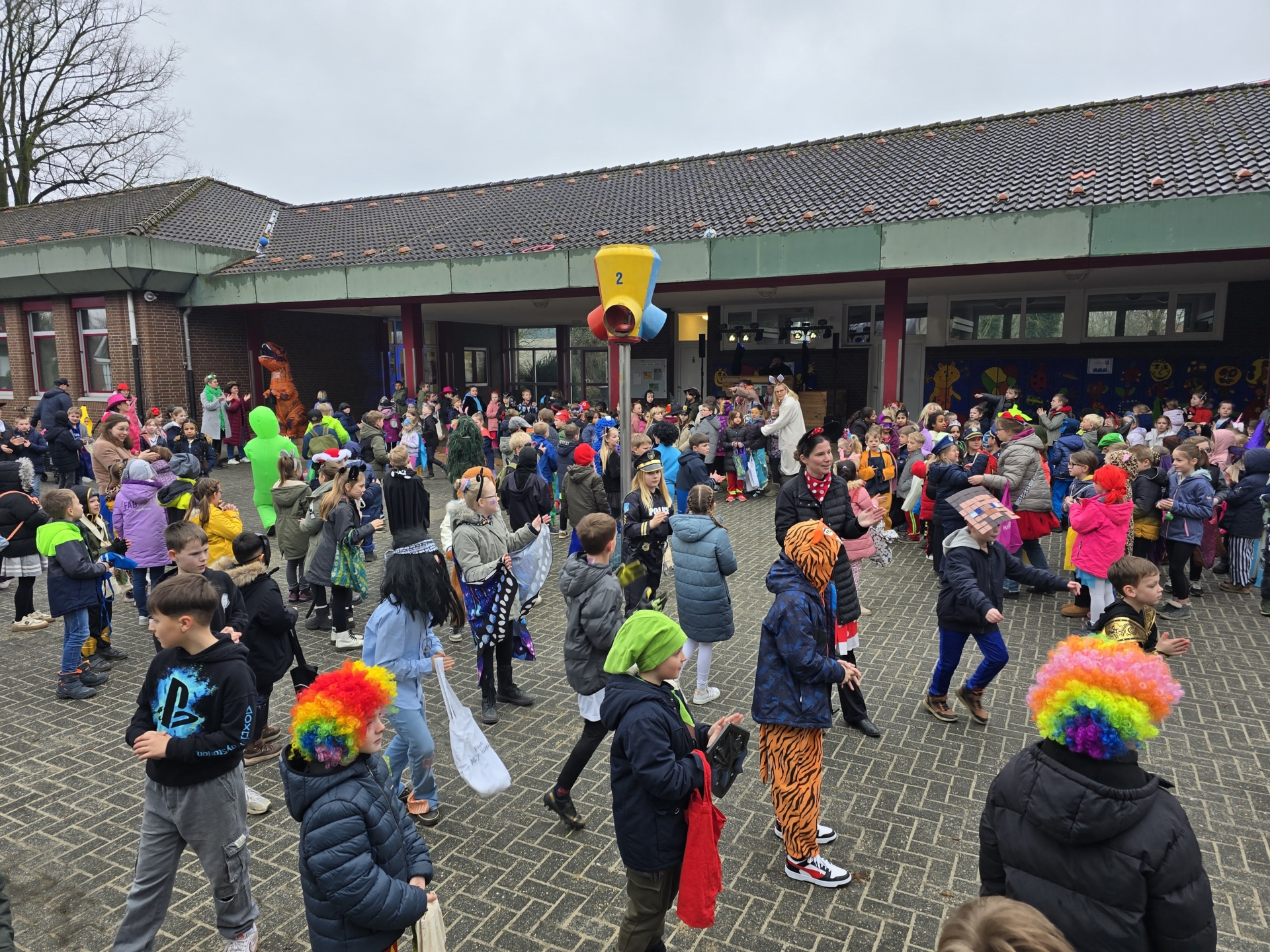 Bild: Prinzessinnen, Clowns, Zebras, Mäuse, Katzen, Polizisten, Cowboys und viele weitere verkleidete Kinder feiern auf dem Schulhof