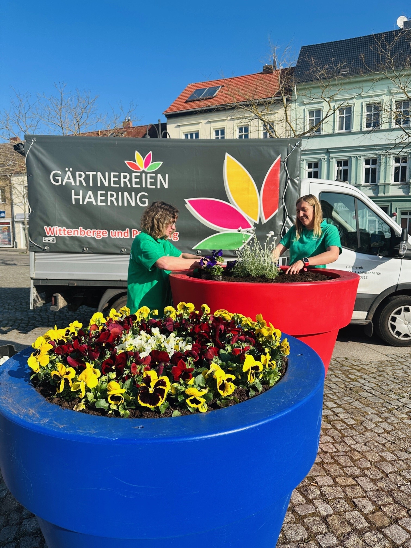 Bild: Melanie Sahm und Sabrina Haering bepflanzen die bunten Blumentöpfe auf dem Bismarckplatz