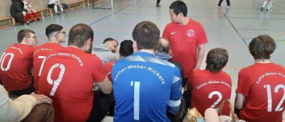 Die Spieler:innen sitzen zu einer Mannschaftsbesprechung zusammen  (Bild vergrößern)