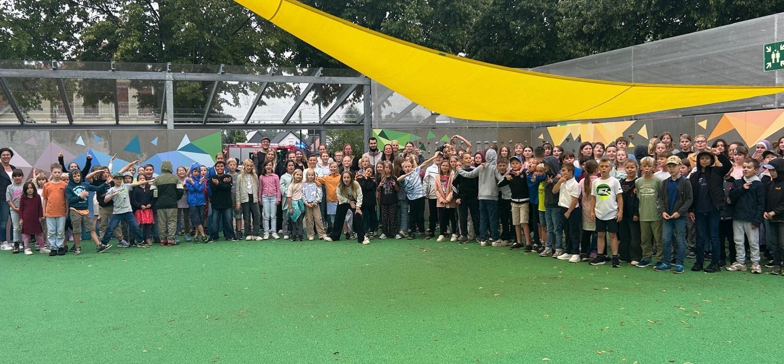 Bild: Die Schülerinnen und Schüler der Grundschule am Mühlenweg stolz vor ihrer fertig gestalteten Kletterwand