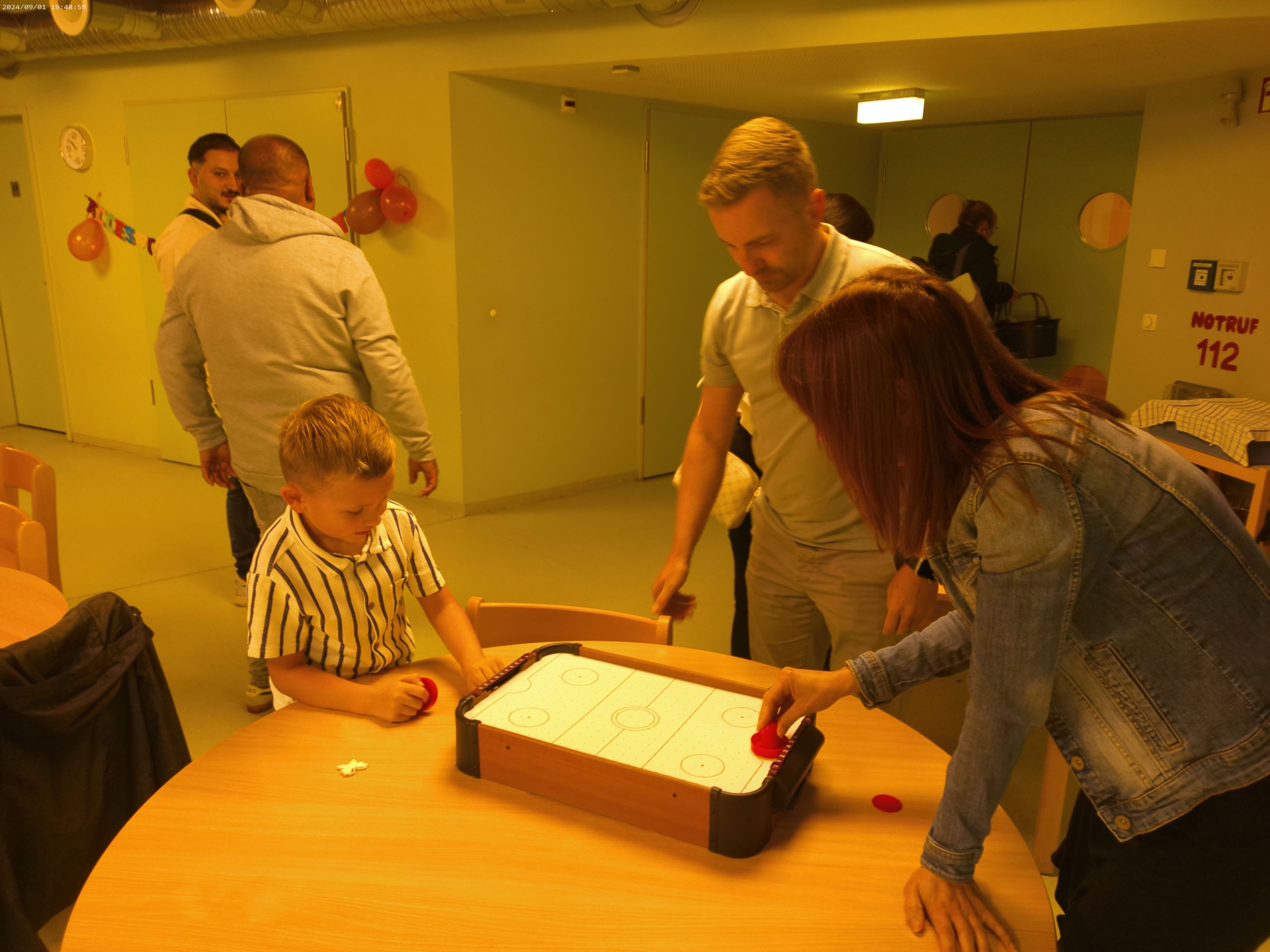 Bild: Mit Mama und Papa am Airhockeytisch.