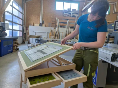 Magdalena zeigt ihren funktionalen Puzzletisch, die Tischplatte kann ergonomisch in drei Winkeln eingestellt werden &ndash; f&uuml;r Puzzeln im Stehen oder im Sitzen.  (Bild vergr&ouml;&szlig;ern)