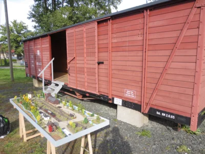 Modelleisenbahn mit Wagon im Hintergrund  (Bild vergr&ouml;&szlig;ern)
