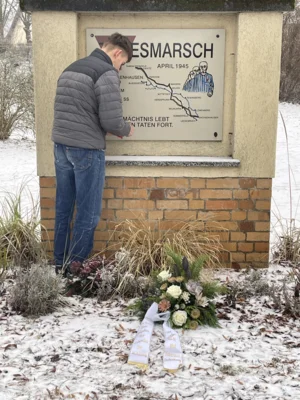 Ein Sch&uuml;ler entz&uuml;ndet ein Grablicht am Mahnmal  (Bild vergr&ouml;&szlig;ern)