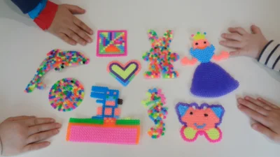 Die Kinder sind eifrig beim Gestalten mit B&uuml;gelperlen dabei und zeigen viel Phantasie.  (Bild vergr&ouml;&szlig;ern)