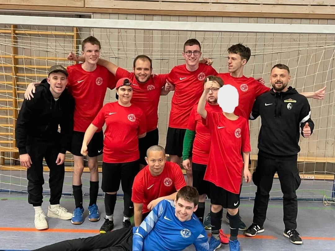 Bild: Mannschaftsfoto der Spieler:innen vor einem Fußballtor
