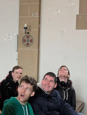 Sch&uuml;pler sitzen in einer Kirche und beobachten Seifenblasen  (Bild vergr&ouml;&szlig;ern)