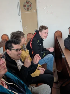 Sch&uuml;ler:innen sitzen in Kirchenb&auml;nken  (Bild vergr&ouml;&szlig;ern)