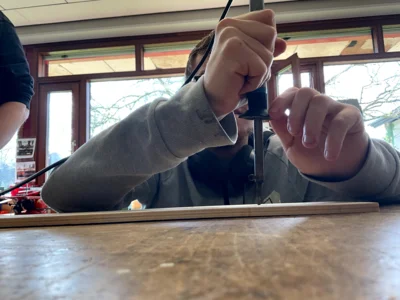 Ein Sch&uuml;ler mit einem L&ouml;tkolben beim Brennen in eine Holztafel  (Bild vergr&ouml;&szlig;ern)