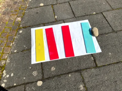 Farblich grundierte Holztafeln in t&uuml;rkis, rot und gelb.  (Bild vergr&ouml;&szlig;ern)