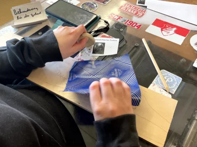 Ein Sch&uuml;ler paust mit Pauspapier wichtige Lebensereignisse auf eine Holztafel  (Bild vergr&ouml;&szlig;ern)