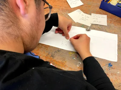 Ein Sch&uuml;ler skizziert wichtige Lebensereignisse auf eine Holztafel  (Bild vergr&ouml;&szlig;ern)
