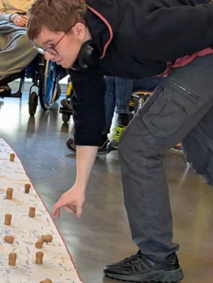 Ein Sch&uuml;ler platziert einen Korken auf das Banner mit Handumrissen  (Bild vergr&ouml;&szlig;ern)