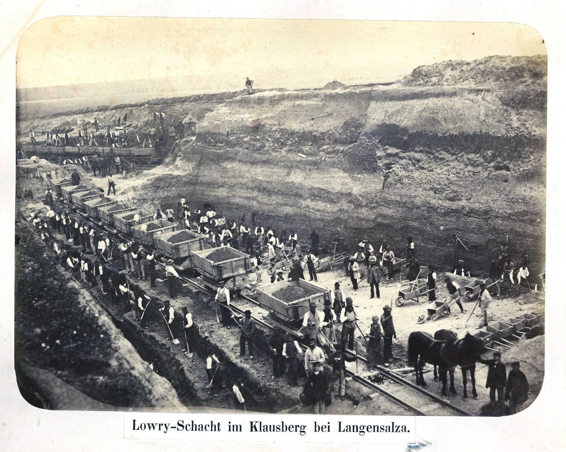 Bild: Bau eines Einschnitts, mühsam werden die Erdmassen von Hand gelöst, auf die Transportwagen verladen und mit Pferden auf Schienengleisen zum Einbauort, der nächsten Dammschüttung, gefahren. (Foto Stadtmuseum Bad Langensalza)