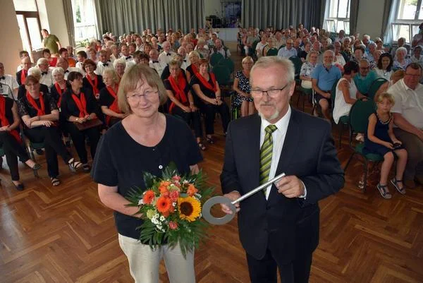 Bild: Die Architektin Bärbel Angermann übergibt symbolisch den Schlüssel an die Gemeinde.