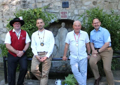B&uuml;rgermeister und Vorsitzender der Thaldorfer Pfingstburschen Andreas Nette, der neue Brunnenherr Christian Sch&auml;fer, der Brunnenherr der Saison 2025/26 Dietrich Lehmann und der B&uuml;rgermeister der Partnerstadt Karlstadt, Michael Hombach (v.l.n.r.)  (Bild vergr&ouml;&szlig;ern)