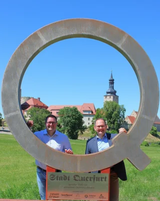 In diesem Jahr extra zum Knoblauchmittwoch angereist: Michael Hombach (re.), B&uuml;rgermeister der Partnerstadt Karlstadt. Beide B&uuml;rgermeister sahen sich das Projekt des Brunnenherren 2025/26, Dietrich Lehmann, an. Das Q als Fotopunkt f&uuml;r Querfurt.  (Bild vergr&ouml;&szlig;ern)