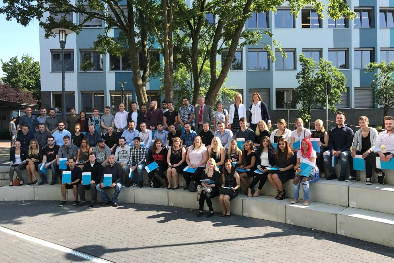 Bild: Unsere Kaufleute im Einzelhandel, Verkäuferinnen und Verkäufer sowie Industriekaufleute Die Klassen AWEO1, AWEM1 und AWIO1 mit ihrer Bereichsleitung Elisabeth Brockmeyer-Schmitt und ihren Klassenlehrern Christian Weiß (Industriekaufleute), Rüdiger Schneider (Einzelhandel) und Klassenlehrerin Dörte Stuckenbrock-Kamps (Einzelhandel)
