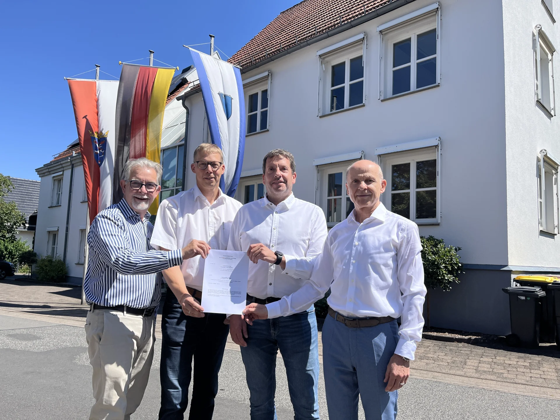 Bild: Präsentation des neuen Konzessionsvertrags vor dem Ebersburger Rathaus in Schmalnau (von links): RhönEnergie-Geschäftsführer Martin Heun, Erster Beigeordneter Ulrich Herold, Bürgermeister Benjamin Reinhart und OsthessenNetz-Geschäftsführer Andreas Bug.