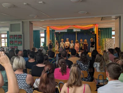 Die erste Klasse verabschiedete sich in der bis auf den letzten Sitz- und Stehplatz gef&uuml;llten Aula mit einem Gedicht von Lehrerin Anita Greiner.  (Bild vergr&ouml;&szlig;ern)