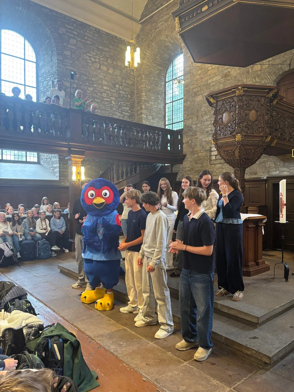 Bild: Das Schulmaskottchen begrüßt die neuen 5er beim Gottesdienst.