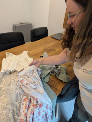 Ein weiteres Hobby: N&auml;hen. Anna Weber zeigt ihre selbst gefertigte Hochzeitsausstattung mit eingesticktem Datum.  (Bild vergr&ouml;&szlig;ern)