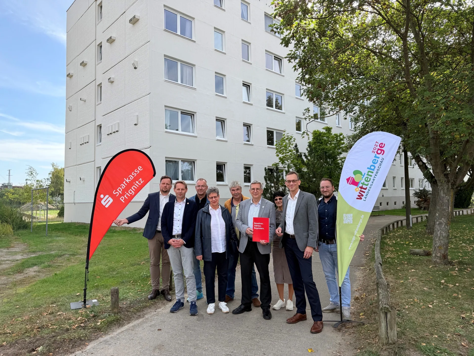 Bild: Projektpartner vor dem Plattenbau der WGW im Bereich der Prignitzer Badewelt (an der Schwimmhalle)