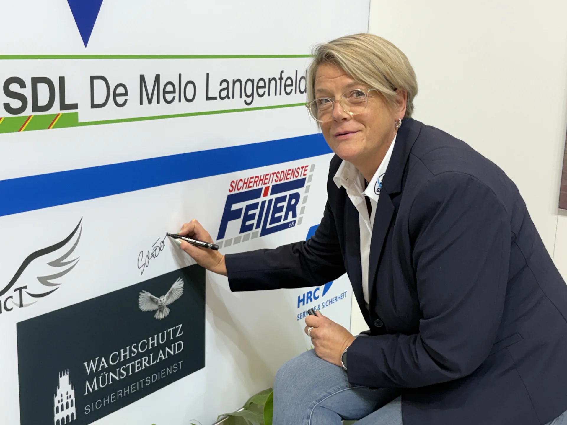 Bild: Karin Schröer (Wachschutz Münsterland) beim Signieren ihres Unternehmenslogos.