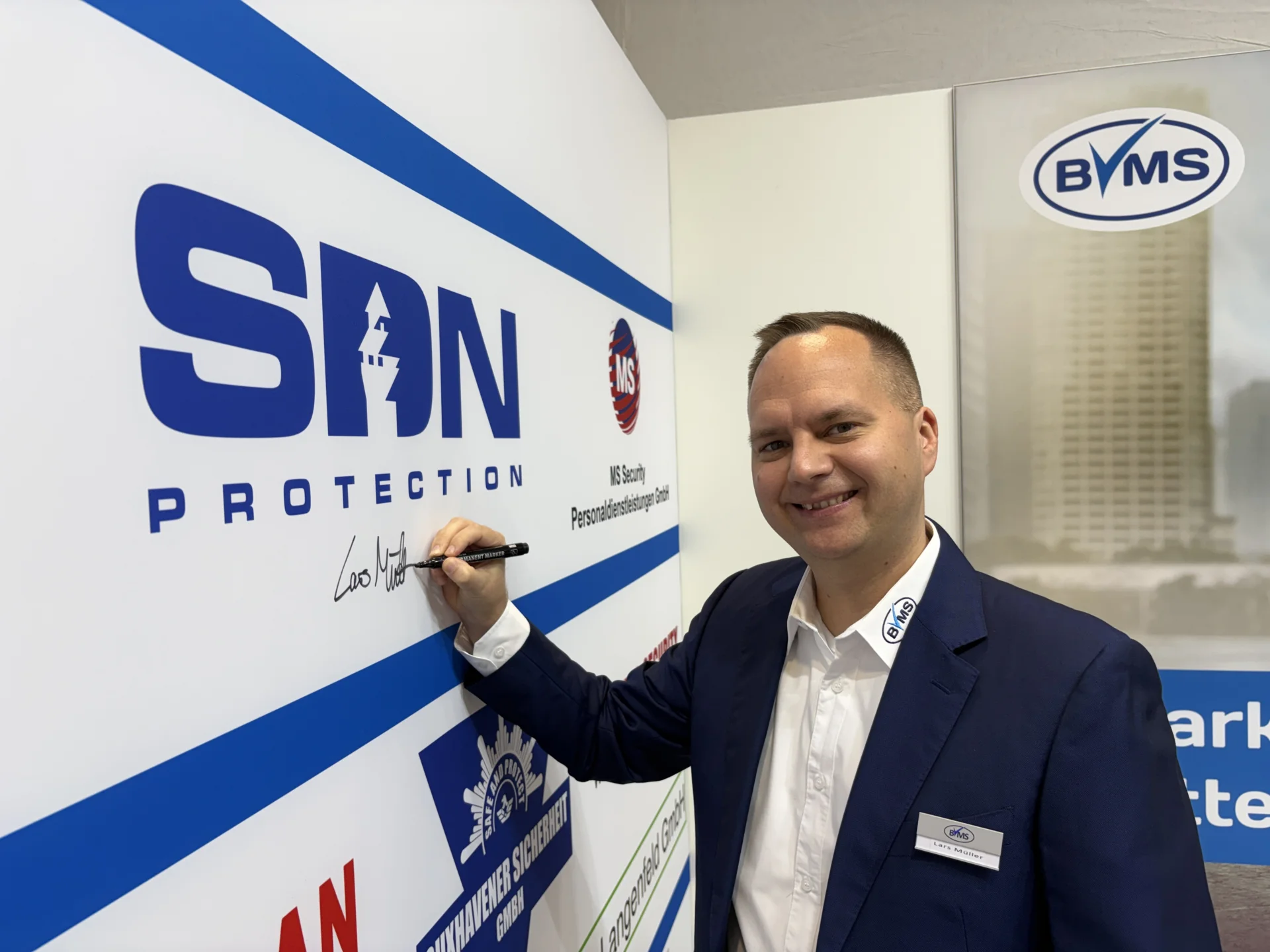 Bild: Lars Müller (SDN Protection) beim Signieren seines Unternehmenslogos.