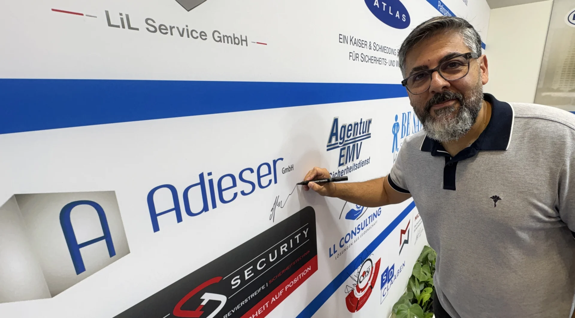 Bild: Maziyar Faezpour (Adieser GmbH) beim Signieren seines Unternehmenslogos.