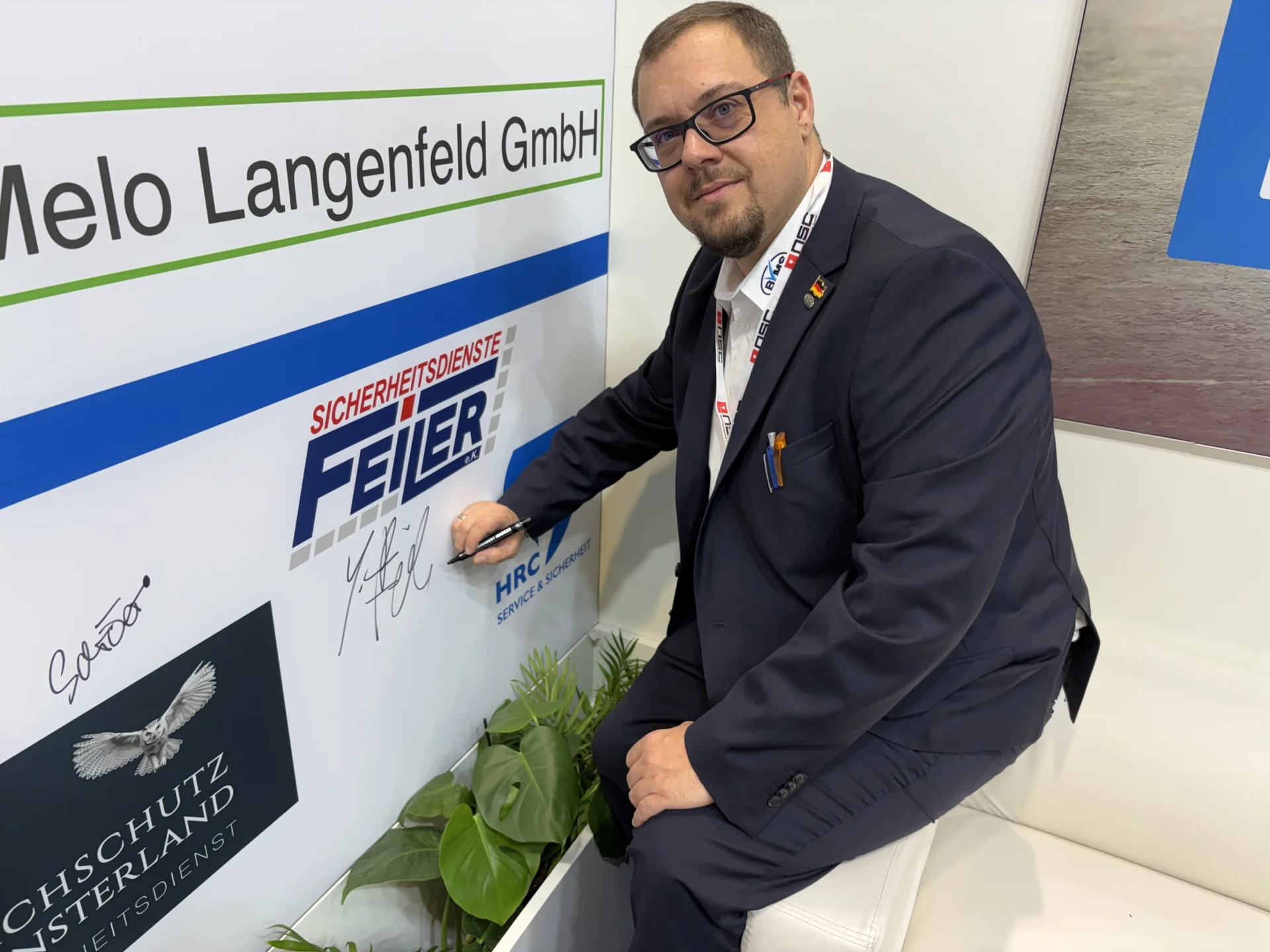 Bild: Sebastian Feiler (Sicherheitsdienste Feiler) beim Signieren seines Unternehmenslogos.