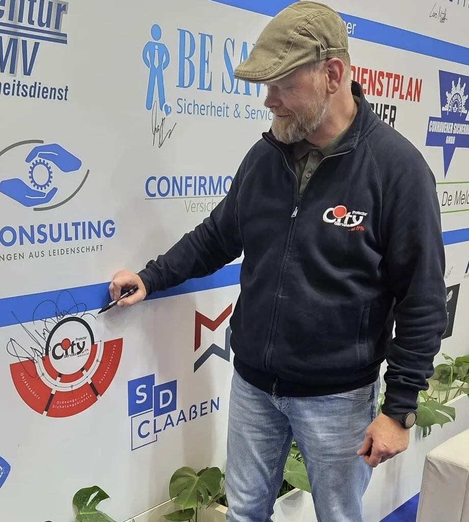 Bild: Stephan Dröst (City Protector) beim Signieren seines Unternehmenslogos.