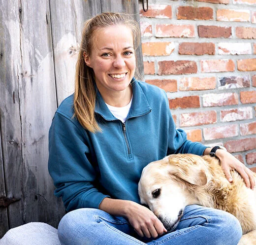 Frau kuschelt mit Hund