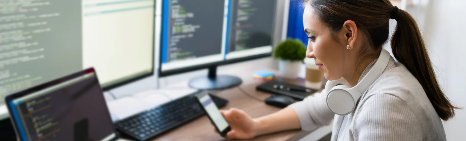 Mitarbeiterin an ihrem Schreibtisch mit vielen Monitoren