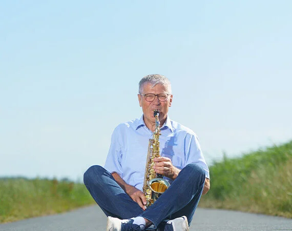 michael-ruf-sitzt-auf-der-strasse-und-spielt-saxophon