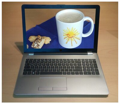 Auf dem Foto sieht man ein Notebook und auf dessen Display eine Kaffeetasse mit dem Wir DABEI!-Logo, welche mit zwei Blätterteig-Stückchen auf einer blauen Serviette steht.