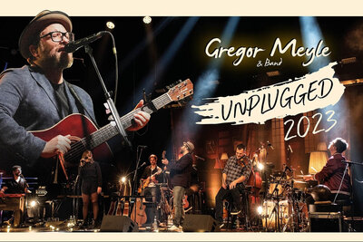 Gregor Meyle singt mit Gitarre und kompletter Band auf der Bühne bei Unplugged-Konzert (Bild vergrößern)