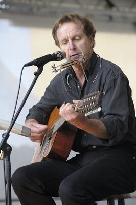 Foto von Roland Berens | zu sehen: er sitzend an der Gitarre und Mundharmonika (Bild vergrößern)