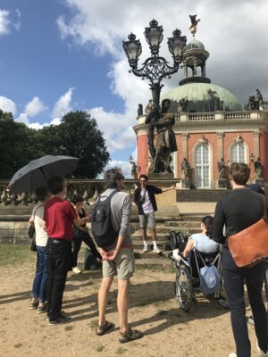 Gruppe an Menschen vor einer Statue im Park Sanssouci