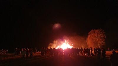 Lagerfeuer umringt von vielen Besuchern
