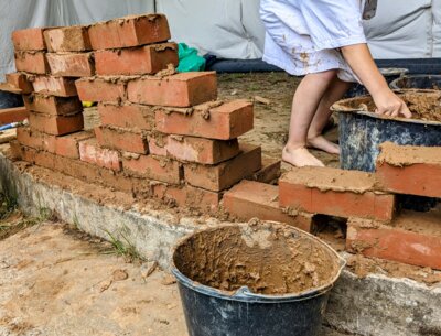 Kinder mauern eine Wand aus Ziegeln und Lehmmörtel. Foto:M.Eschenbach