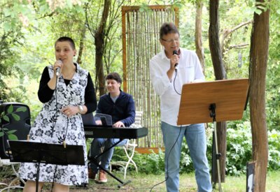 Foto Jürgen Weser: Unterhalten mit ihren Liedern im Hof des Museums Mühlberg 1547 bei Kaffee und Gebäck am 13. Juli v.l.n.r.: Steffi Marschner, Sebastian und Andreas Pöschl.