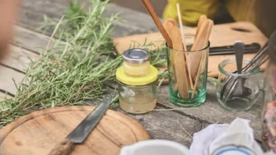 Kräuter und verschiedene Utensilien auf einem Tisch (Bild vergr&ouml;&szlig;ern)