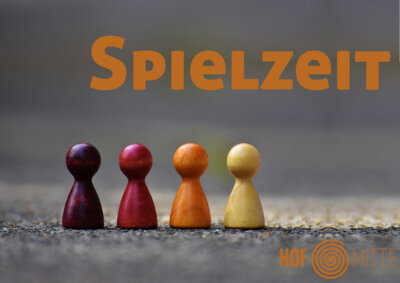 Spielzeit - Bunte Spielfiguren stehen nebeneinander.