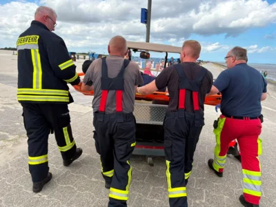  Mittels Golfcart und Schleifkorbtrage wird der Patient zum Rettungwagen gefahren.